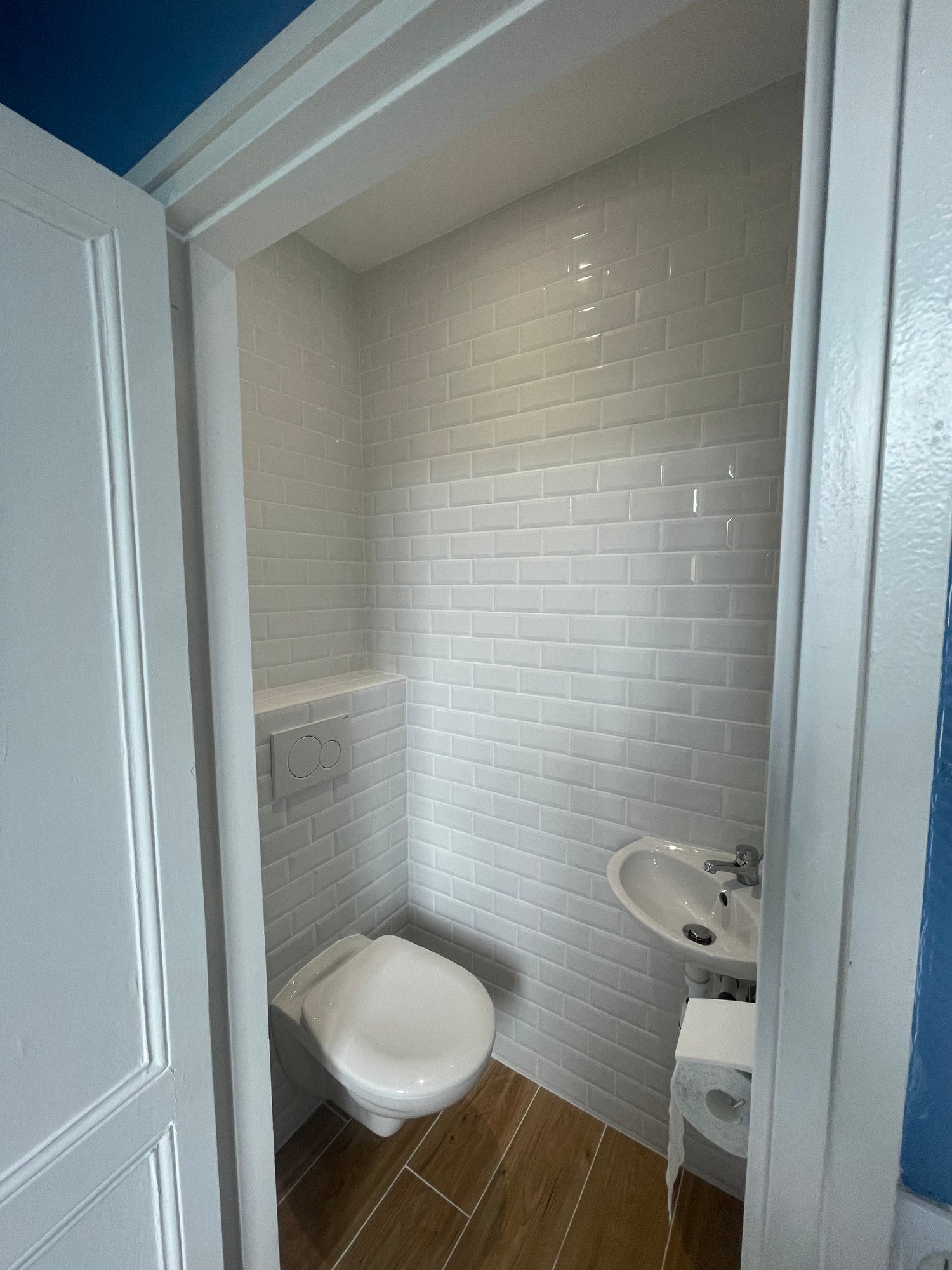 WC suspendu Geberit et lave-main dans salle de bain rénovée